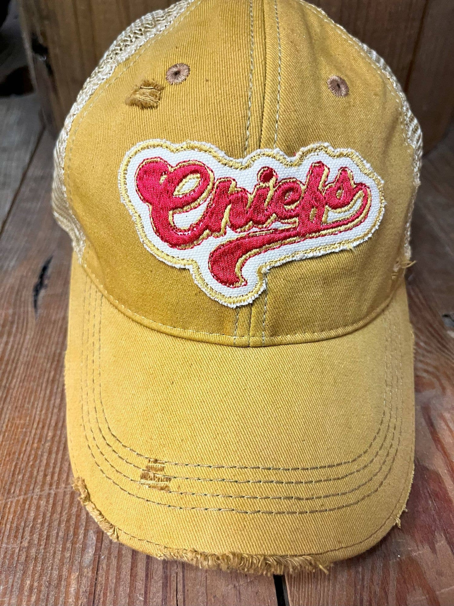 Yellow cap with 'Chiefs' logo on a wooden surface