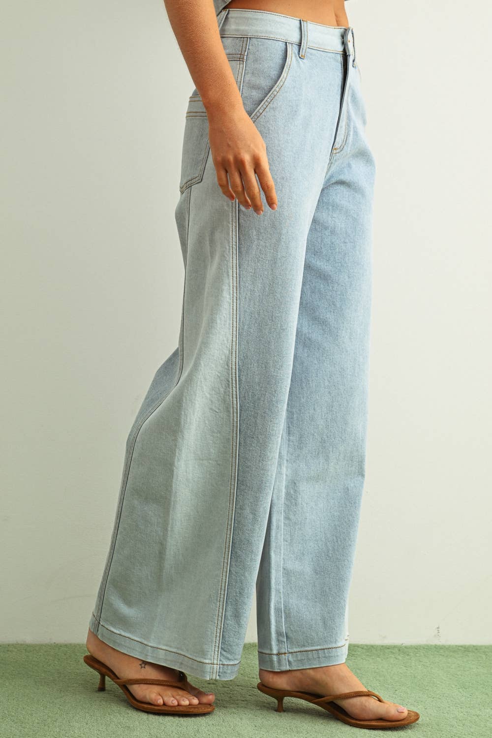 Light blue jeans worn by a person on a plain background
