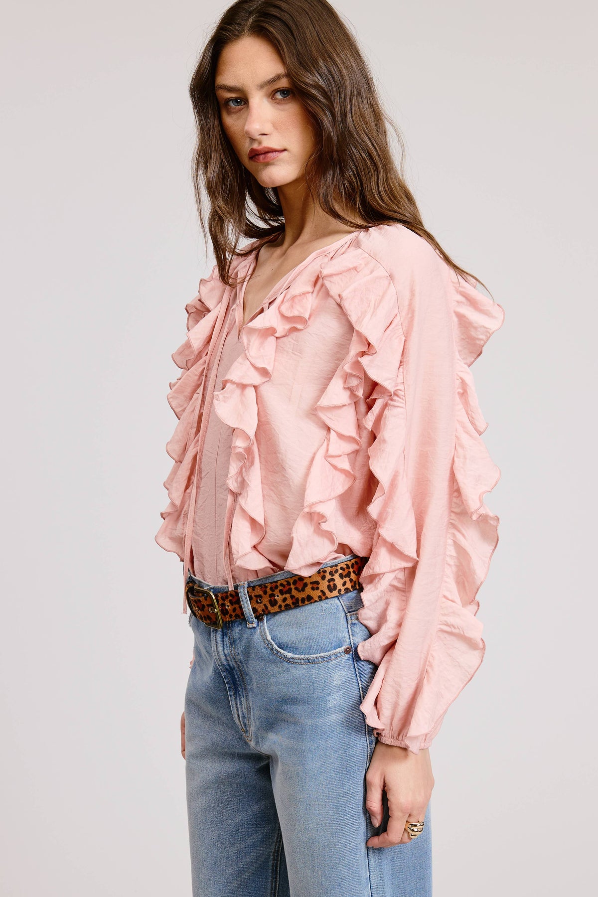 Side view of the Rosalie Ruffle Top by Mimosa in blush pink, a ruffle-trimmed blouse with V-neckline and tie detail