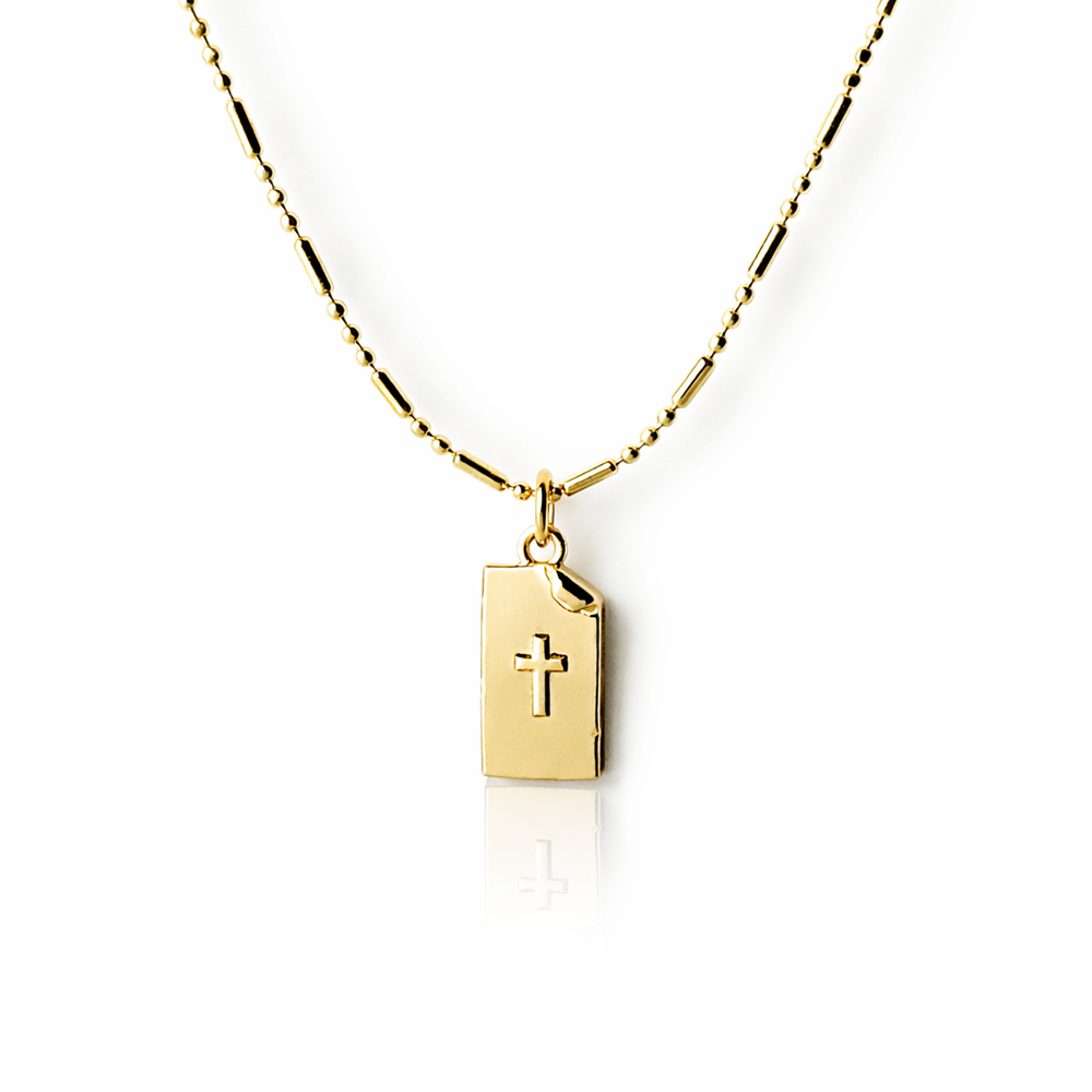 Gold necklace with a pendant featuring a cross on a white background