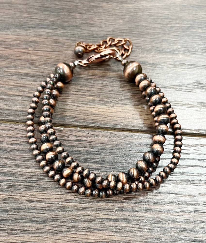 Copper beaded bracelet on a wooden surface