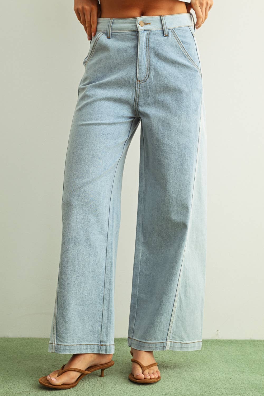 Light blue jeans worn by a person on a neutral background