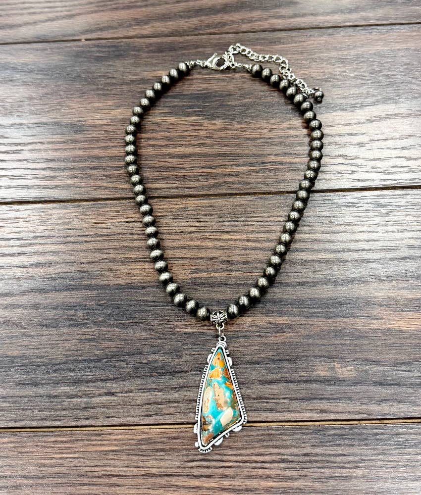 Necklace with a turquoise stone pendant on a wooden surface
