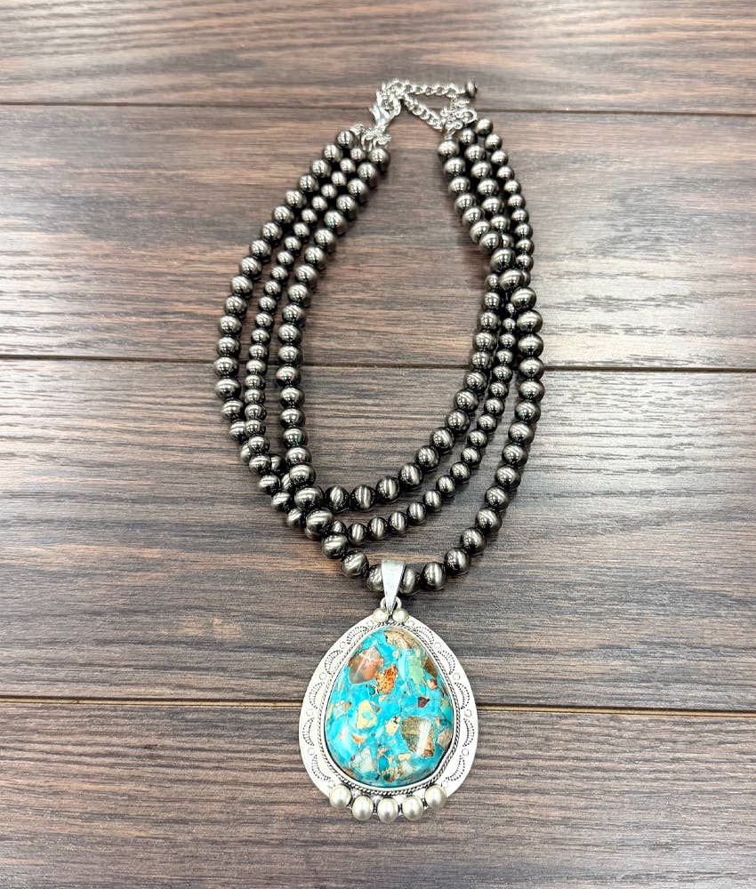 Necklace with a turquoise pendant on a wooden surface